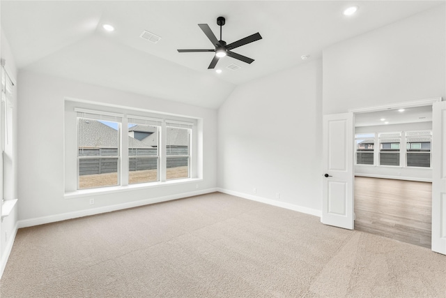 carpeted empty room featuring vaulted ceiling and ceiling fan