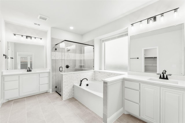 bathroom with tile patterned floors, vanity, and plus walk in shower