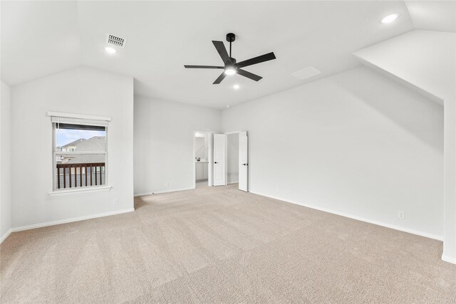 interior space with ceiling fan, vaulted ceiling, and light colored carpet