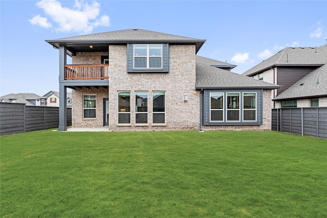 back of house with a patio area, a yard, and a balcony