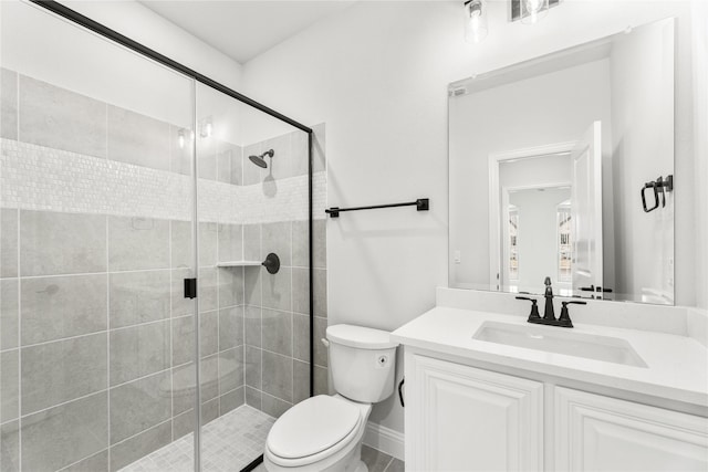 bathroom featuring toilet, a shower with shower door, and vanity