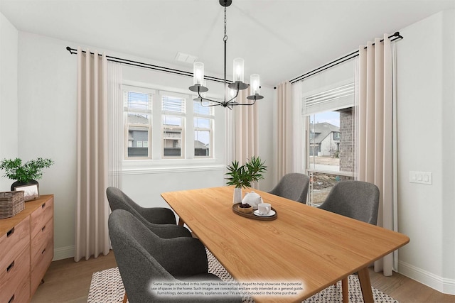 dining area featuring light wood-type flooring and an inviting chandelier