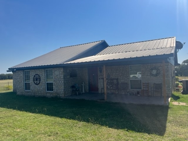 back of property featuring a lawn and a patio