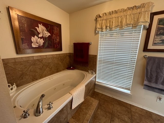 bathroom featuring tile patterned floors and a relaxing tiled tub