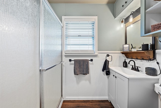 bathroom featuring walk in shower, wood finished floors, and vanity