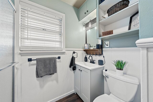 bathroom featuring toilet, a wainscoted wall, a wealth of natural light, and vanity