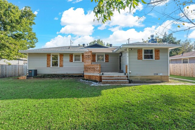 view of front of property with a front yard, central AC unit, and fence