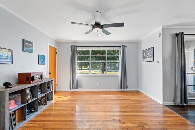 unfurnished room featuring wood finished floors, ceiling fan, crown molding, and baseboards