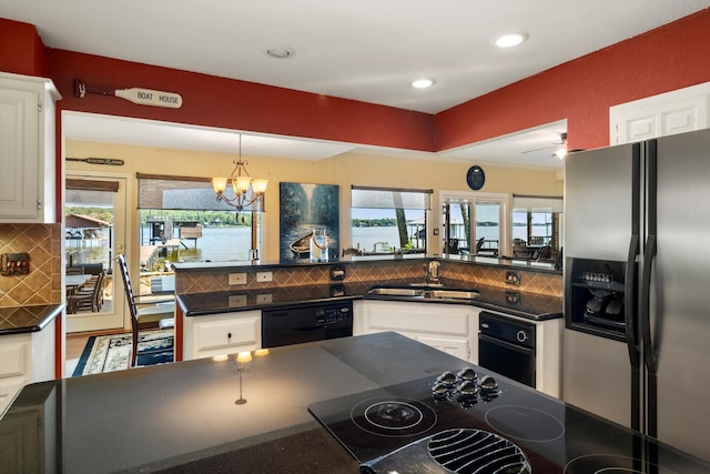 kitchen with sink, an inviting chandelier, tasteful backsplash, black appliances, and white cabinets