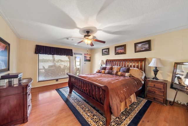 bedroom featuring hardwood / wood-style flooring, ceiling fan, crown molding, and a textured ceiling