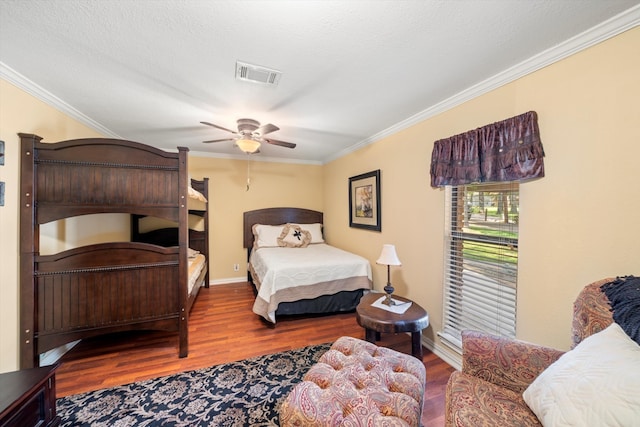 bedroom with wood-type flooring, ornamental molding, and ceiling fan