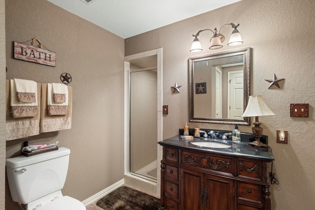 bathroom with walk in shower, vanity, and toilet