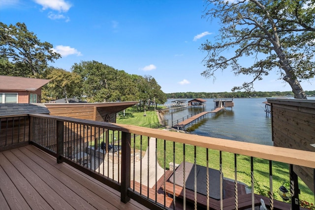 deck with a dock, a water view, and a yard