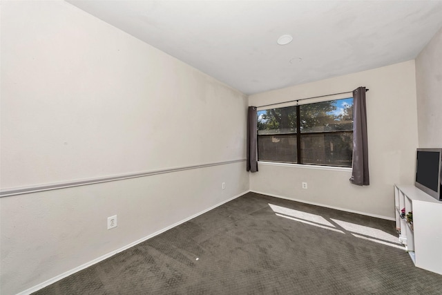 spare room with dark colored carpet