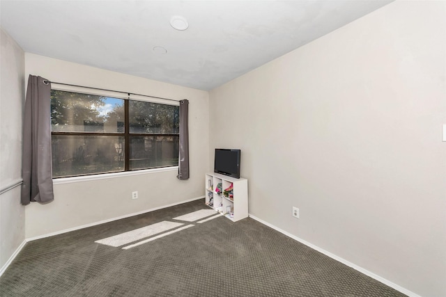 unfurnished room with dark carpet