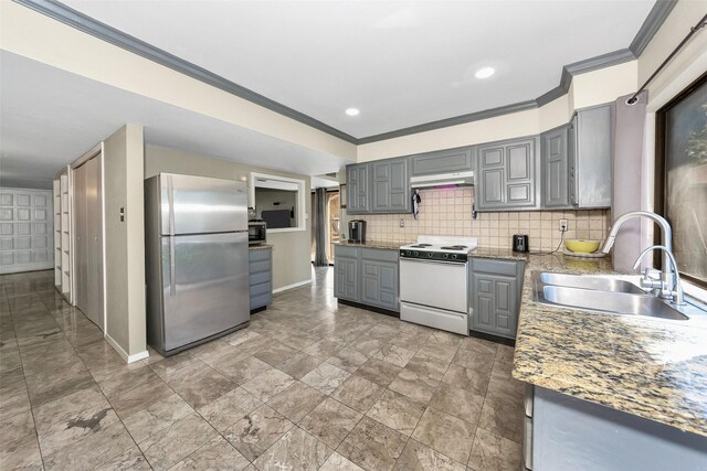 kitchen with appliances with stainless steel finishes, sink, gray cabinetry, and tasteful backsplash