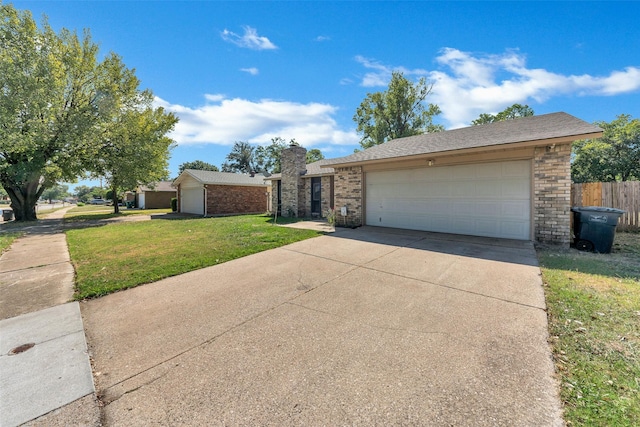 view of front facade featuring a front lawn, brick siding, a garage, a chimney, and concrete driveway