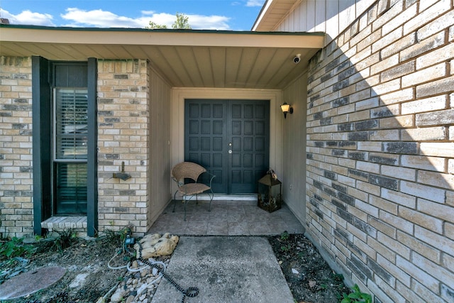 property entrance featuring brick siding