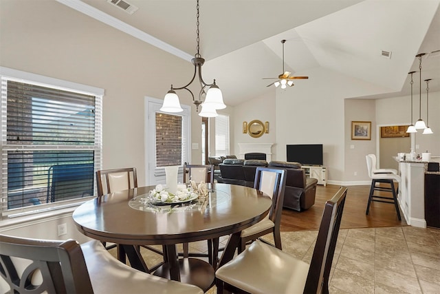 dining room featuring light hardwood / wood-style floors, ornamental molding, lofted ceiling, and ceiling fan with notable chandelier