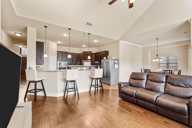 living room featuring light hardwood / wood-style flooring, high vaulted ceiling, crown molding, and ceiling fan