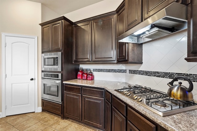 kitchen with premium range hood, tasteful backsplash, stainless steel appliances, and dark brown cabinets