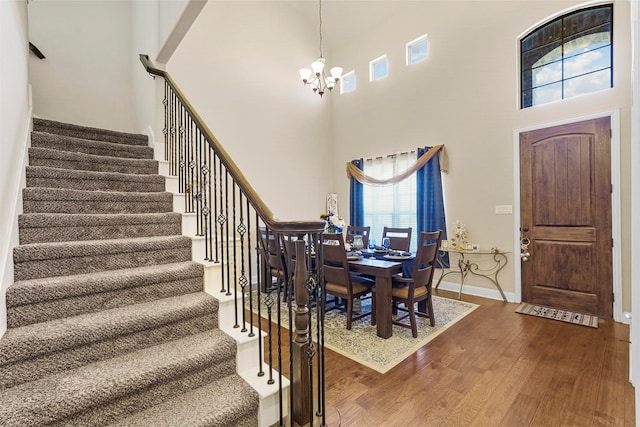 dining area with a high ceiling, a chandelier, and hardwood / wood-style floors