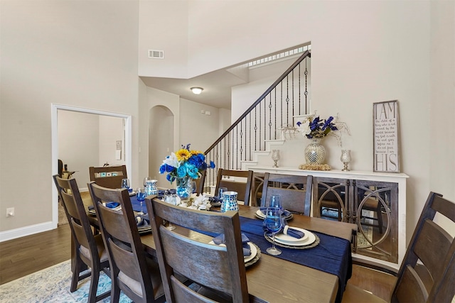 dining area featuring a high ceiling and hardwood / wood-style floors