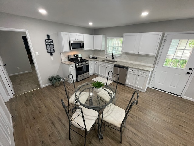 kitchen with dark hardwood / wood-style flooring, white cabinetry, appliances with stainless steel finishes, and sink