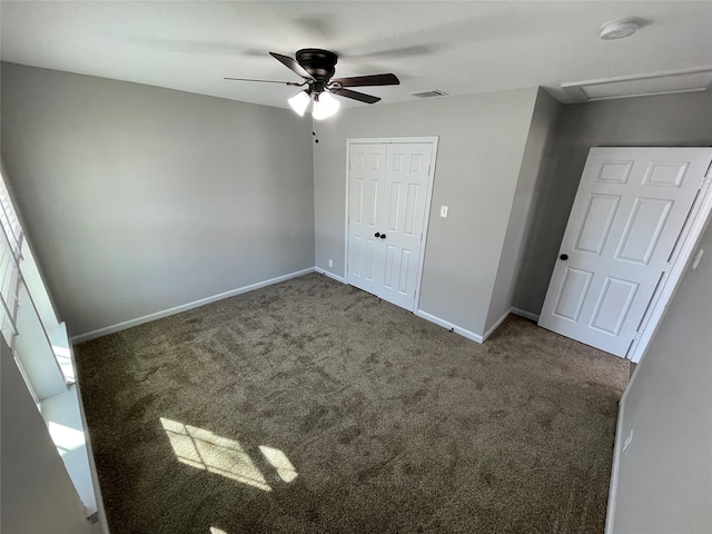 unfurnished bedroom with dark carpet, a closet, and ceiling fan