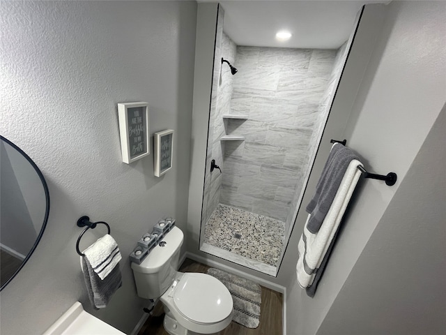 bathroom with toilet and a tile shower