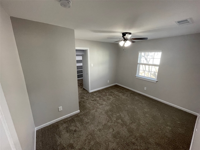 unfurnished room featuring dark colored carpet and ceiling fan