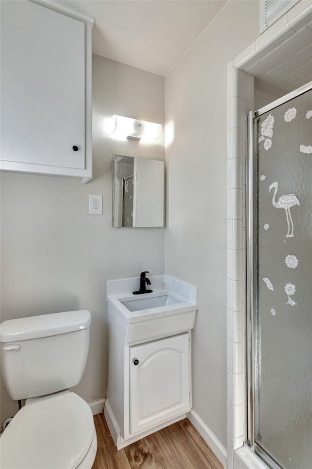 bathroom with wood-type flooring, vanity, toilet, and an enclosed shower