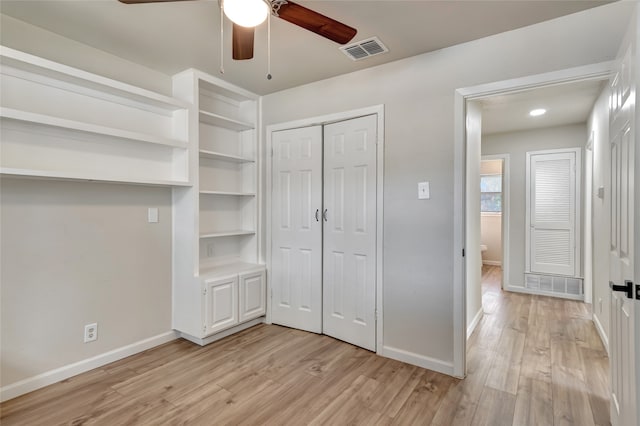 unfurnished bedroom with ceiling fan, light wood-type flooring, and a closet