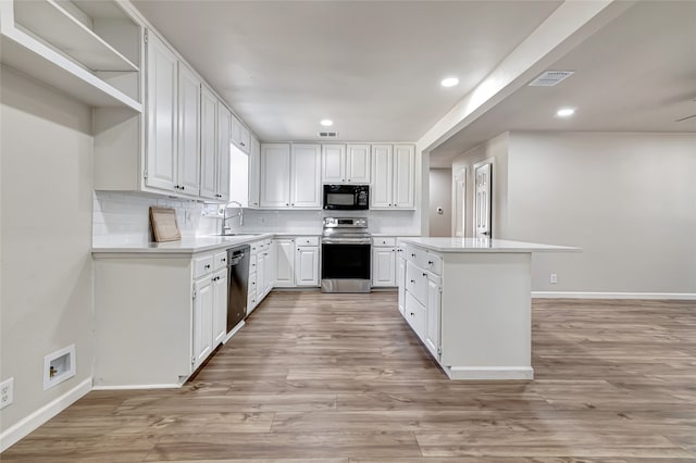 kitchen featuring light wood-type flooring, sink, white cabinetry, backsplash, and appliances with stainless steel finishes