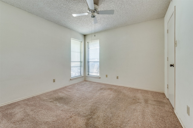 carpeted spare room with a textured ceiling and ceiling fan