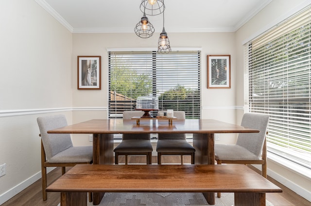 dining space with ornamental molding, a wealth of natural light, and hardwood / wood-style flooring