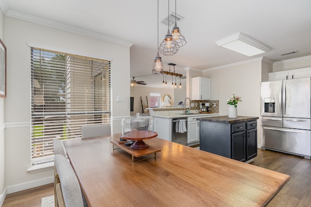 dining room featuring ornamental molding, plenty of natural light, and dark wood-type flooring