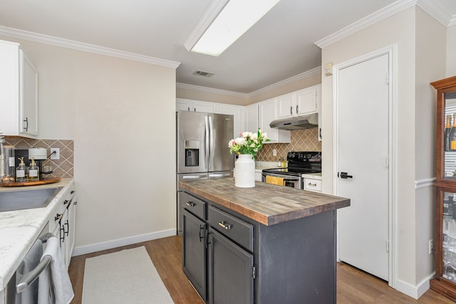 kitchen featuring wood-type flooring, white cabinets, appliances with stainless steel finishes, and butcher block counters