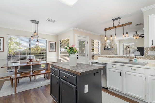 kitchen with pendant lighting, white cabinets, a center island, and sink