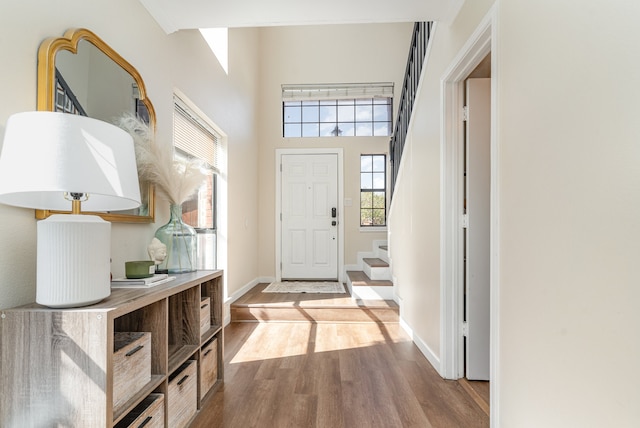 foyer entrance with light wood-type flooring and a high ceiling