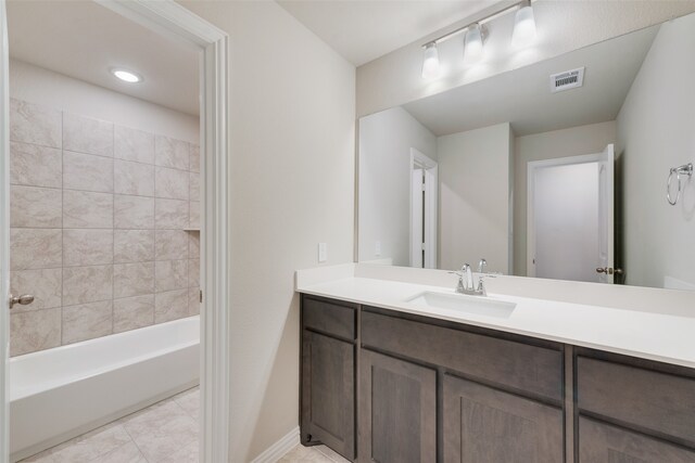 bathroom featuring tile patterned flooring, vanity, and tiled shower / bath