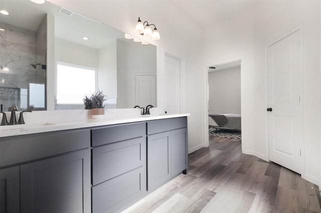 bathroom with vanity, hardwood / wood-style flooring, and tiled shower