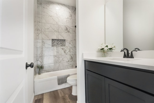 full bathroom featuring vanity, wood-type flooring, toilet, and tiled shower / bath