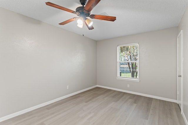 empty room with ceiling fan, a textured ceiling, and light wood-type flooring