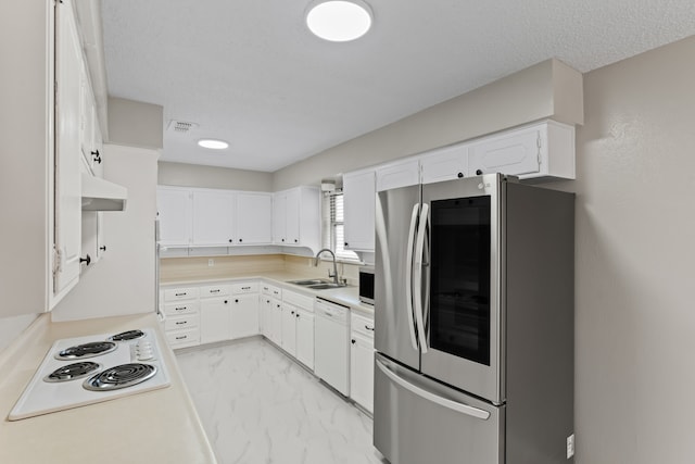 kitchen with white appliances, sink, a textured ceiling, and white cabinetry