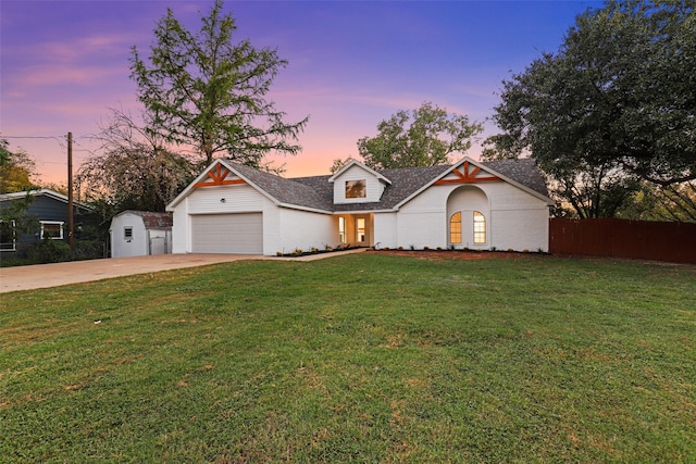 view of front of property with a garage and a lawn