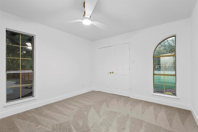 empty room featuring ceiling fan and carpet floors