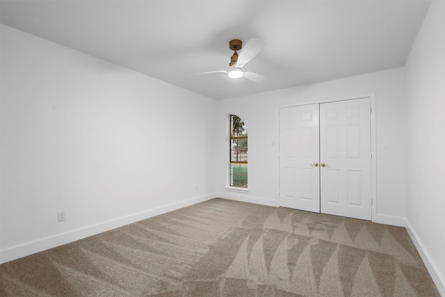 unfurnished bedroom featuring ceiling fan, carpet floors, and a closet