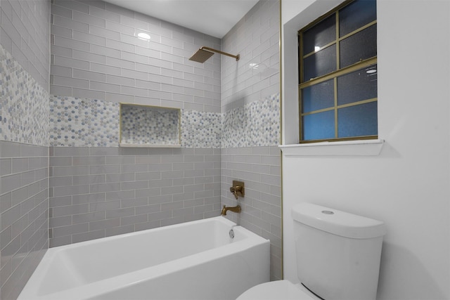 bathroom featuring tiled shower / bath and toilet