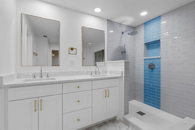 bathroom featuring a tile shower and vanity